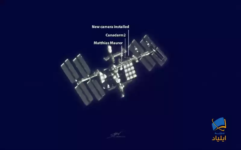 ایستگاه فضایی بین‌المللی و دو فضانوردی که در حال انجام پیاده‌روی فضایی در اطراف ایستگاه هستند